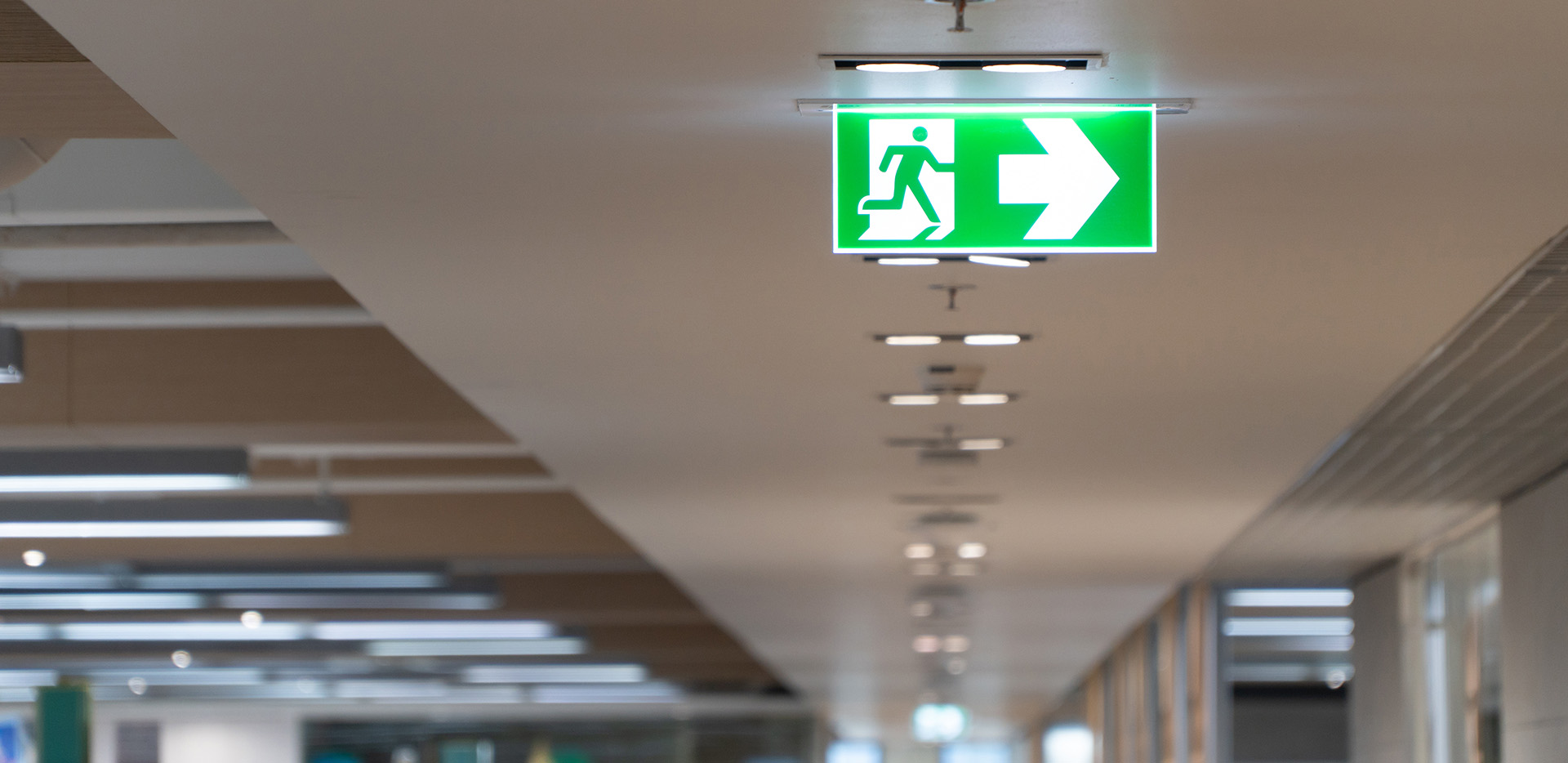 Beleuchtetes Notausgangschild mit Pfeil zur Kennzeichnung eines Fluchtwegs